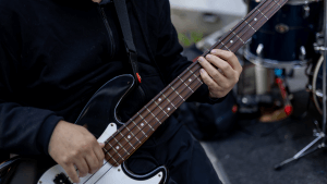 a musician with a guitar on water street