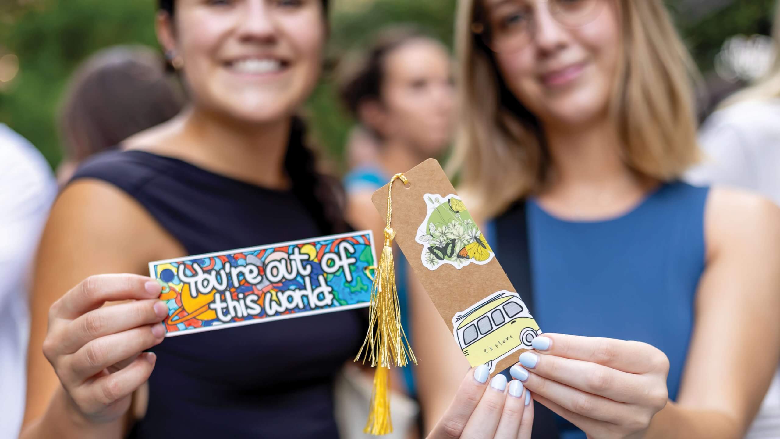 Two women show book marks during cover to cover in Water Street